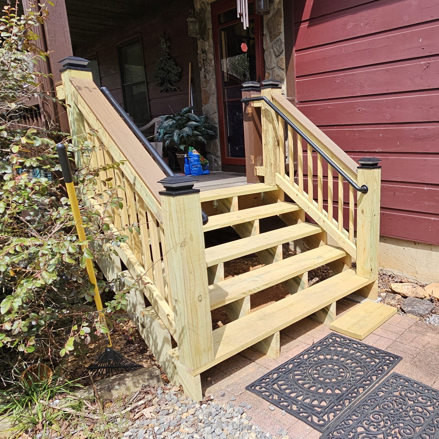 New front porch steps with wood railing and black handrail