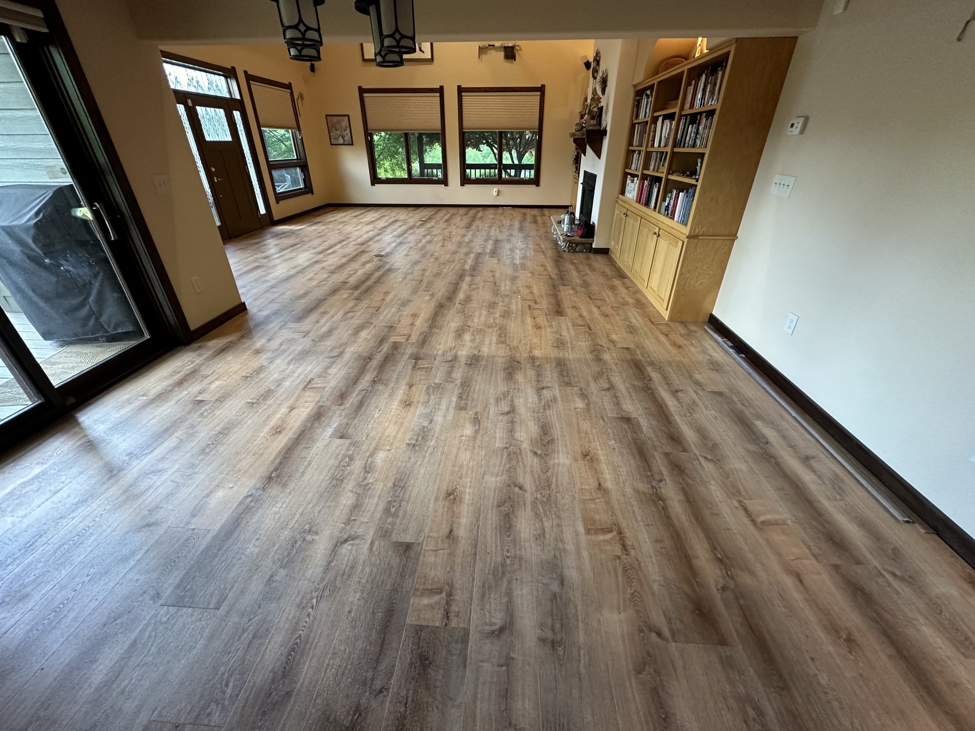 Open living and dining room with new wide-plank LVP flooring installed wall to wall