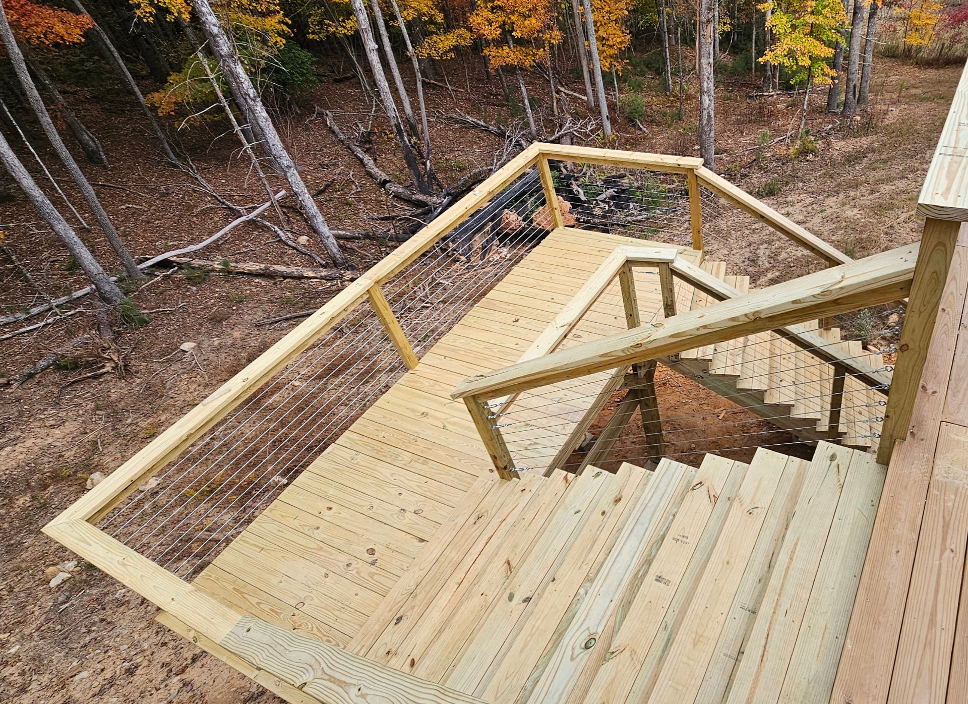 New pressure-treated deck landing and stairs with cable railing